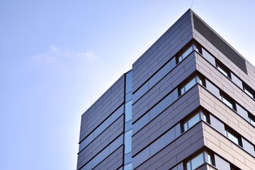 A view at a straight facade of a modern building with a dark grey facade.