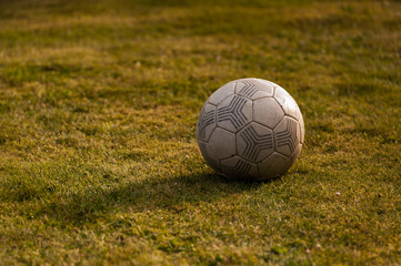Old football on grass, close-up