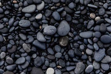 view of black sand and black stones on a beach in Iceland