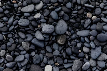 Blick auf schwarzen Sand und schwarze Steine an einem Strand in Island © Alexander