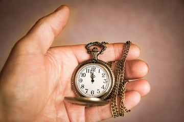 Naklejka premium a pocket watch in the hands of a man