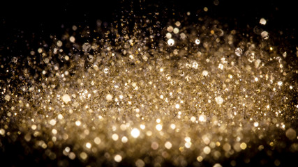 explosion of sparkling gold dust on a black background.