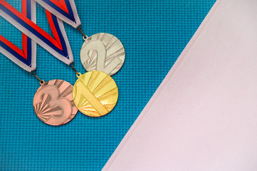 Gold silver and bronze medal on blue background. White edit space. Original wallpaper for summer...