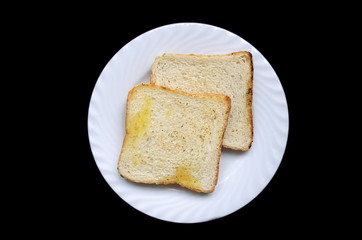Plate with toasted bread isolated on black background, top view