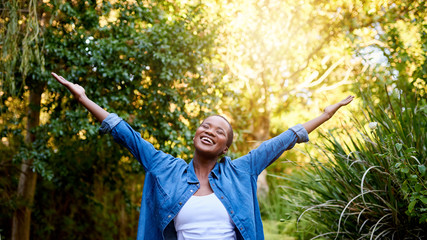 Smiling young African American woman embracing a sunny summer day