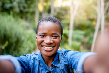 Young African American woman smiling and taking selfies outdoors