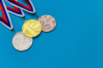 Gold silver and bronze medal on blue background. Medal schedule concept photo, empty edit space....