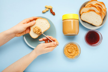 Top view,flat lay process of cooking breakfast, spreading bread, toast with peanut butter, creamy...