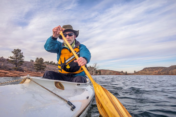 senior male is paddling expedition canoe