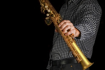 Fototapeta na wymiar soprano saxophone in hands on a black background
