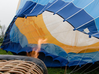 Flame which heat up in the hot air balloon. Parts of the wicker basket for the transport of passengers can be seen in the front waistband