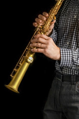 Fototapeta premium soprano saxophone in hands on a black background