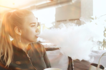 girl smokes a hookah at the bar / smoking, health, modern cigarettes vape