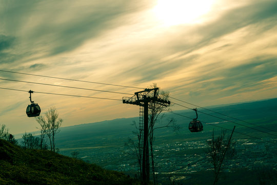 Cable car over mountain settlements and cable cars on the descent.