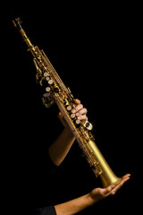 Obraz premium soprano saxophone in hands on a black background