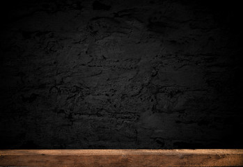 Empty wooden table on a dark concrete background, blurred brick wall, empty space for the product above.