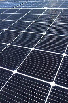 A tight group of newly installed solar panels, perfect for a background or texture image, in vertical format