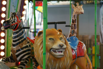 Fototapeta na wymiar City amusement park. Photography of the lion, giraffe and zebra as a parts of carousel. Concepts of fun and childhood.