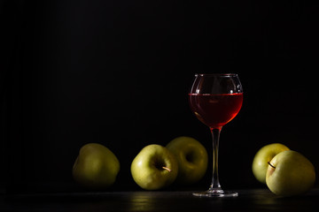 A glass of red fruit wine. Apples fresh crop, still life in a low key. Copy space. Banner for cafe, winery and restaurant.