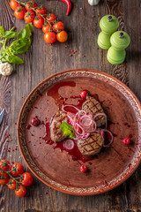 Veal medallions with cherry sauce, served with pickled onions and radishes, a gourmet dish, Close up, Top view