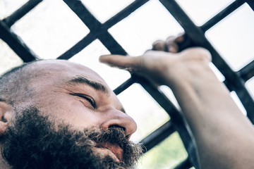 muzhza with a beard behind bars. concept of imprisonment