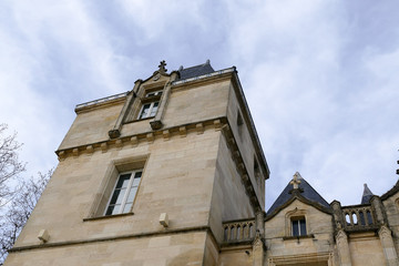 Closeup architectural details of ancient historic castle or chateau in France - against blue sky white clouds