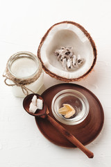 Coconut cosmetic background. Coco oil and milk on white wooden background. Free copy space mockup. Handmade natural cosmetics for hair and face care.