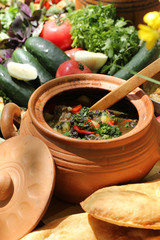 Georgian cuisine. Georgian concept, clay pottery in nature. Lunch with herbs, fresh vegetables and national dishes