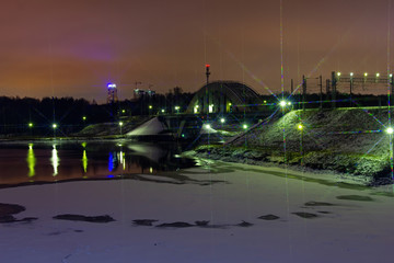 Fototapeta na wymiar Night view of the icy river and bridge on new year's eve.
