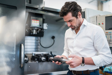 Man holding drillhead in a factory