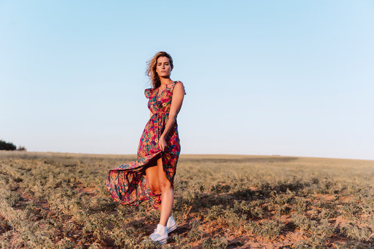 Blond woman wearing summer dress with closed eyes at countryside