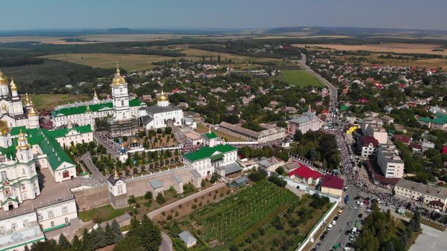 Top view of the Pochaev Lavra at the moment when a lot of people enter it. Orthodox procession in the monastery.