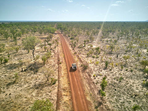 Benin, Aerial view of 4x4 car driving along dirt road in Pendjari National Park