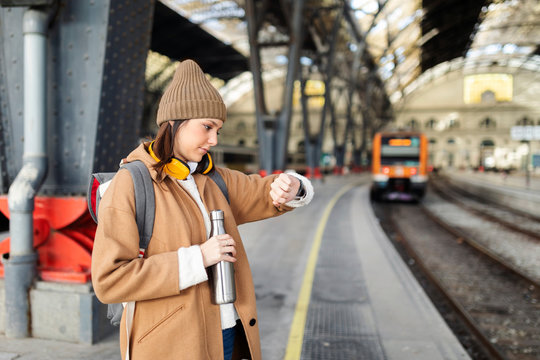Young woman checking the time at the train station