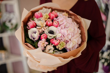 Close-up of girl holding bouquet with poppies and peonies