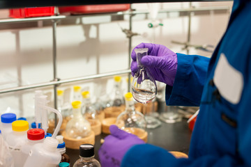 Preparing to add clear liquid from a Florence flask in a lab