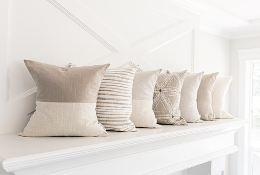 Neutral pillows on a fireplace mantle