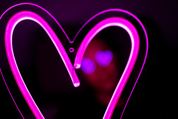 Valentine day. Hipster handsome man with neon signs. Neon sign pink heart. Party concept. Modern...