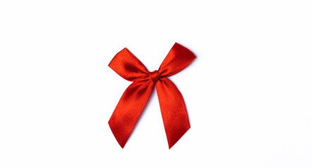 Red satin ribbon bow isolated on white background. The concept of decorating a holiday gift, postcard, banner. Top view. Flat lay. Copy space