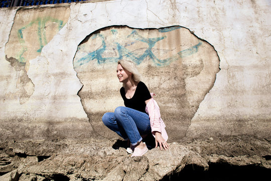 Nice girl near the shattered white wall