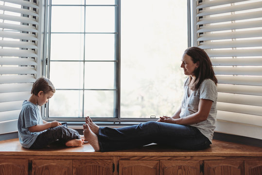 5 yr old son reads to content mom while sitting on window seat