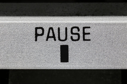 Macro close up photograph of vintage boombox tape player pause button.  