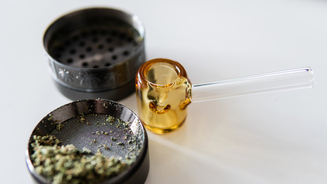 glass smoking pipe and marijuana buds close-up.