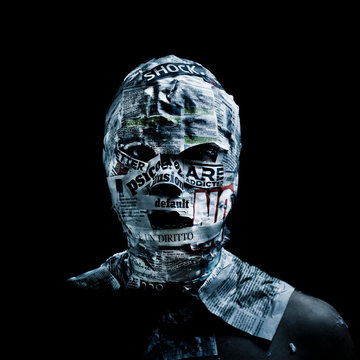 Man covered by newspapers