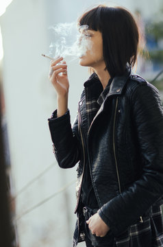 Young girl smoking with cloud puff smoke of face