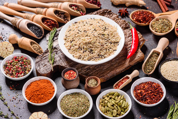 Spices and herbs over black stone background. Top view with free space for menu or recipes
