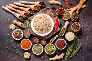 Spices and herbs over black stone background. Top view with free space for menu or recipes