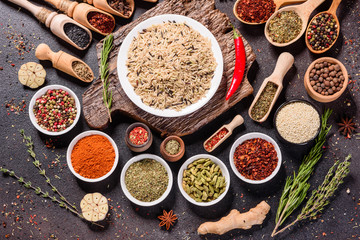 Spices and herbs over black stone background. Top view with free space for menu or recipes