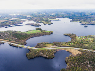 Beautiful view from a road going through the beautiful lake and forest, surrounded with water on...