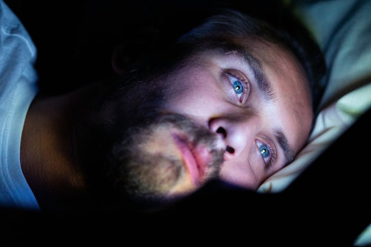 Bearded caucasian male is watching something on his mobile phone